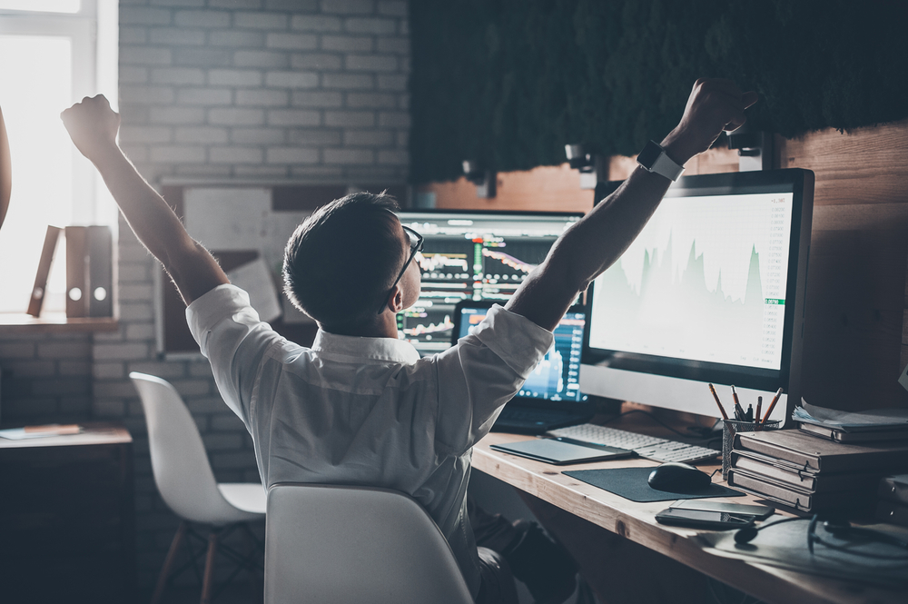 Triumphant sales person at their computer screen